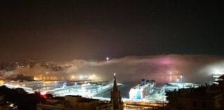 Genova avvolta dalla nebbia che sale dal mare